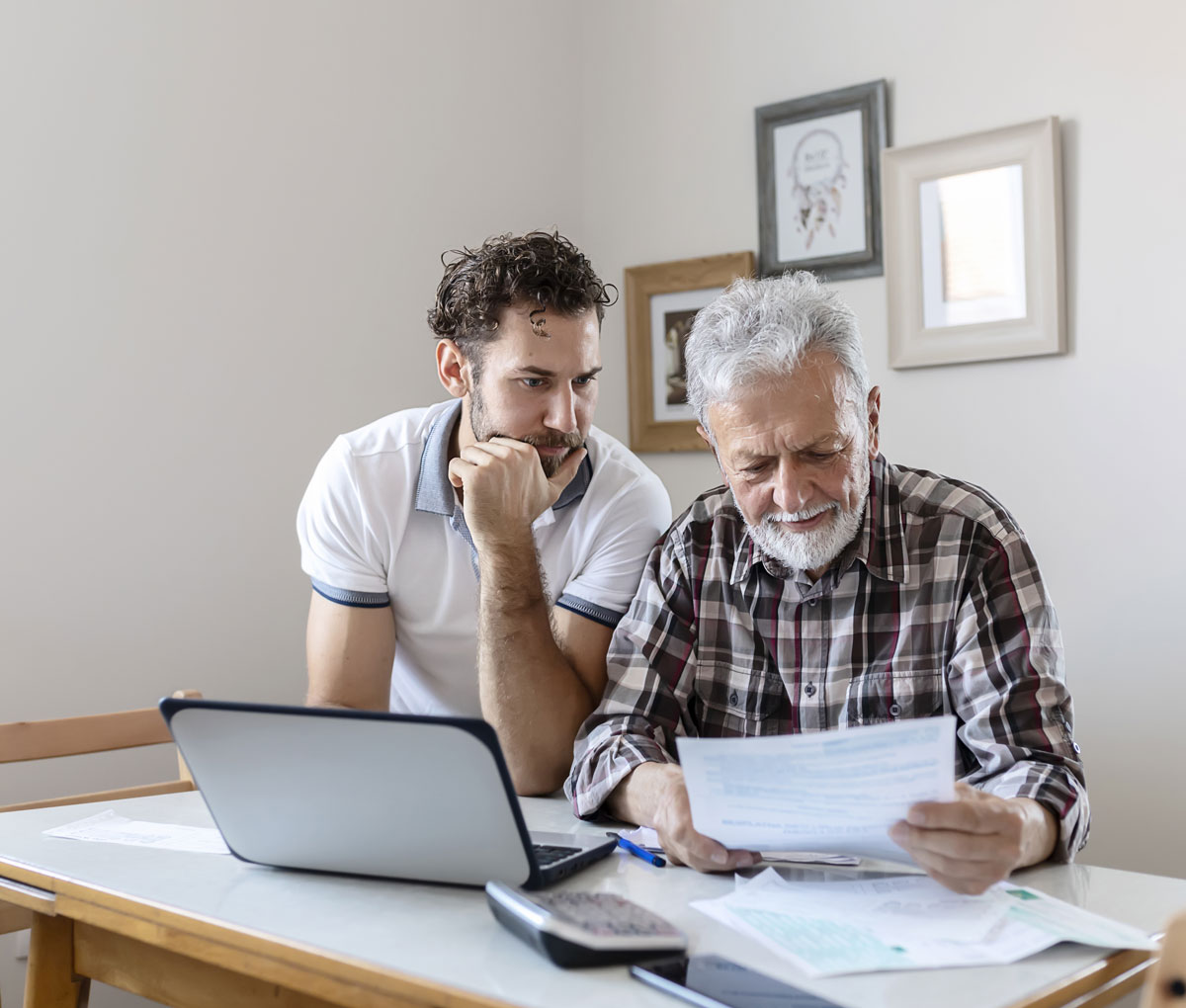 Senior and Adult Child looking at finances on a laptop