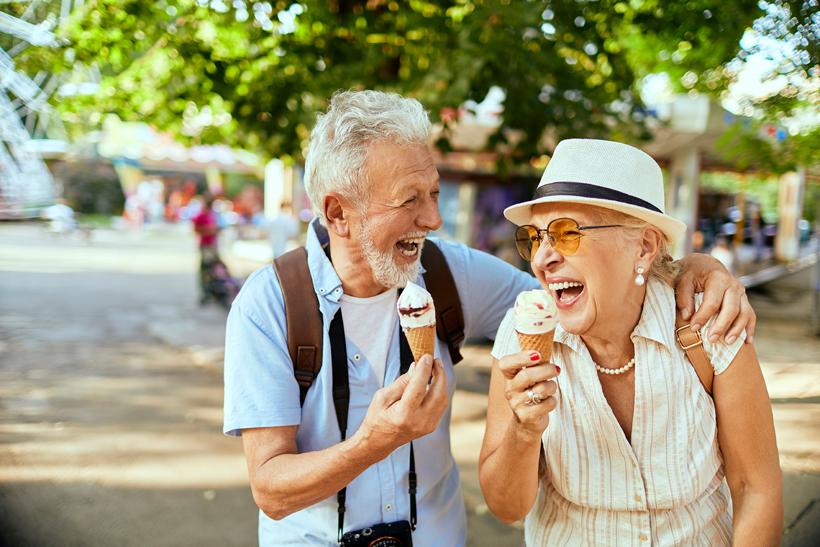 senior couple eating ice cream and laughing outside senior couple eating ice cream and laughing outside