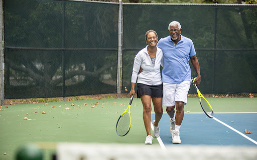 senior couple walking off the court after a round of tennis